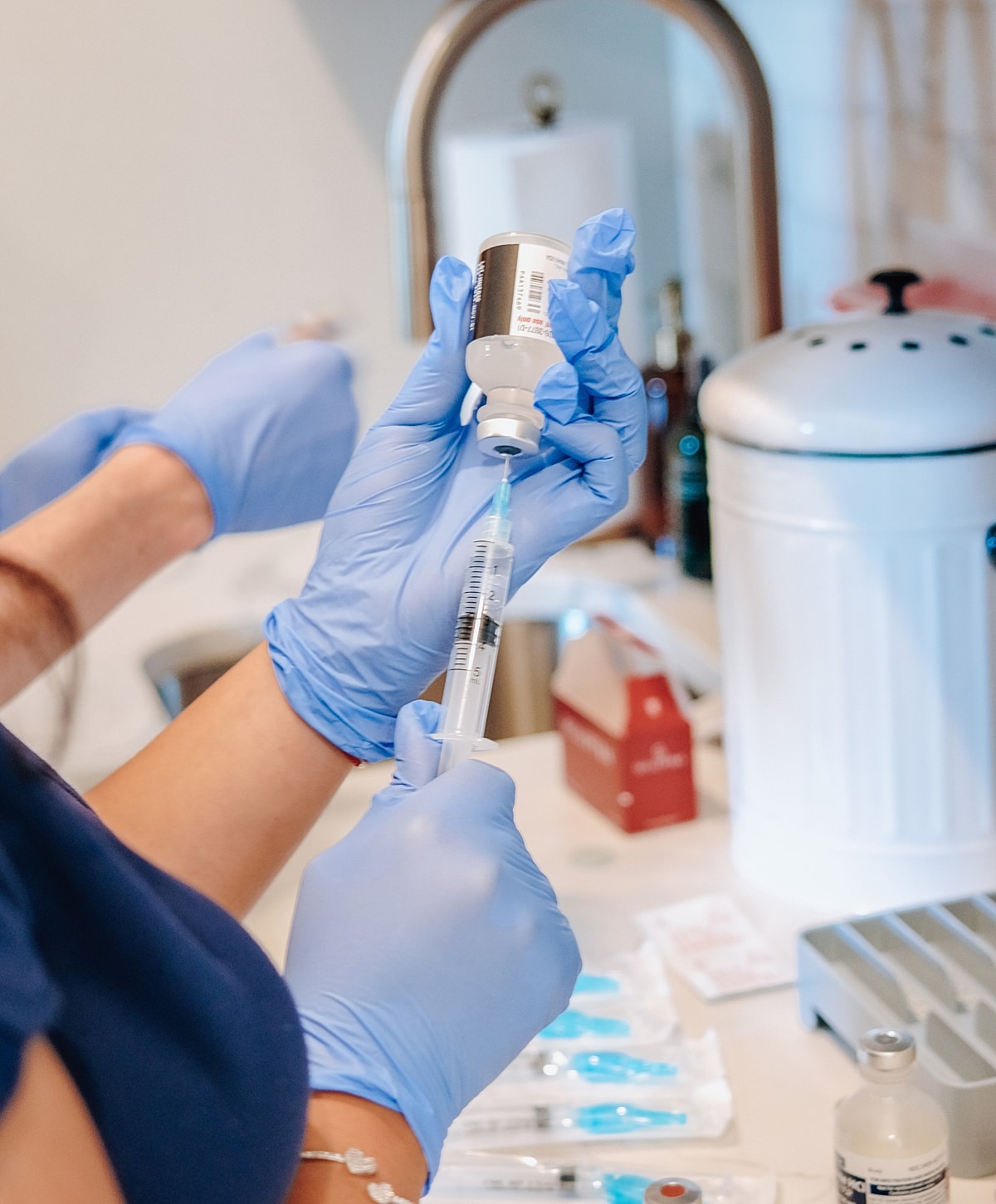 Preparing a syringe with medication in gloves.