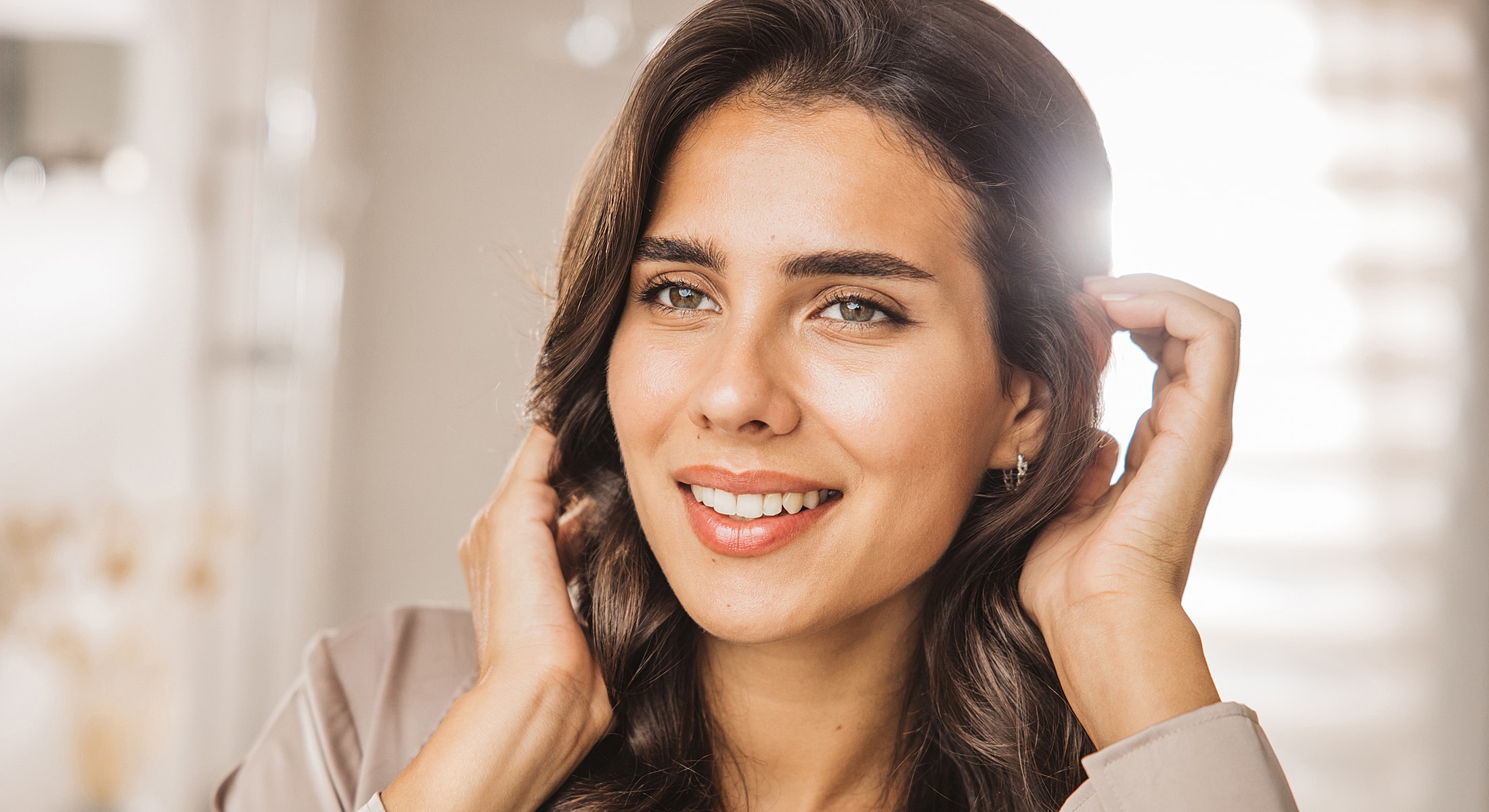 Young woman smiling with long, wavy hair.