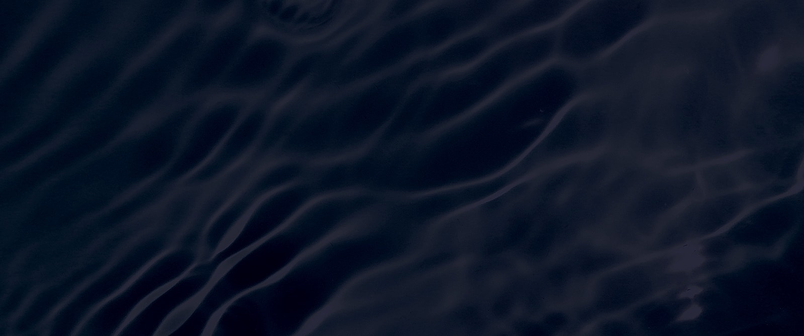 Dark textured marble background with wavy patterns.