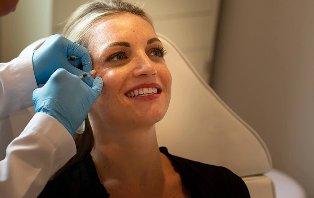 Woman receiving aesthetic treatment in clinic setting.